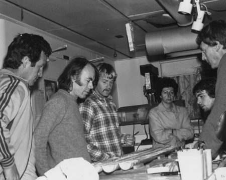 Members of the Leg 74 scientific team confer over sliced cores in the Sediment Libratory aboard D/V Glomar Challenger (shi...