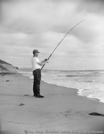 Man on beach surf fishing