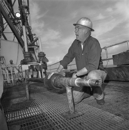 Robert R. Knapp examining a piece of broken drill pipe on board the D/V Glomar Challenger (ship), during one of the Legs o...