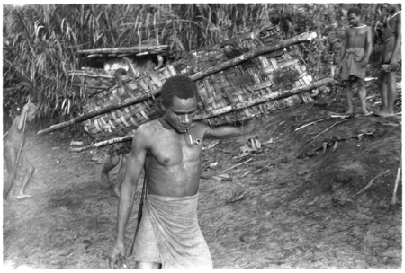 Man carrying a taro pudding for fa&#39;asafinga desacralization ritual connected with mourning for recent death.
