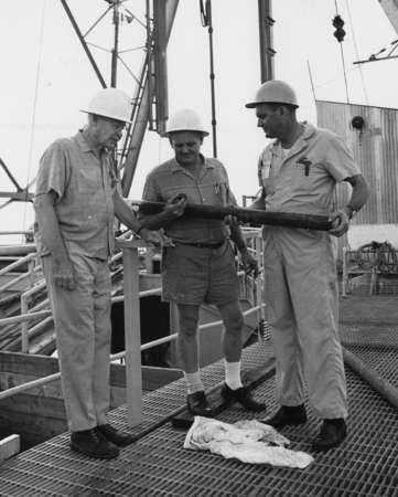 Oil-Laden Core-Dr. Maurice Ewing (left), of Lamont Geological Observatory, looks at a piece of oil-laden sedimentary core ...