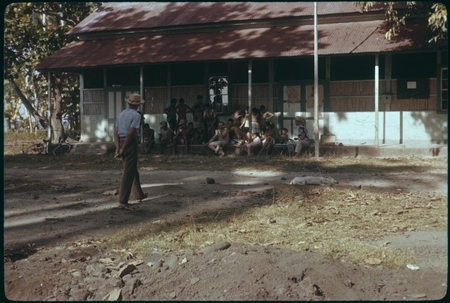 Artist on school house steps, Society Islands, surrounded by crowd