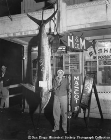 Man with fishing rod posing with swordfish caught from H &amp; M Sport Fishing Company boat Mascot III