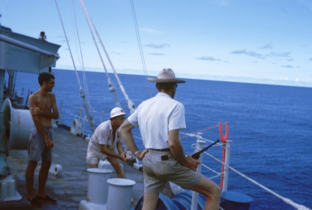 Unidentified scientist are shown here skeet shooting for some fun, on the research ship Argo during the Lusiad Expedition ...