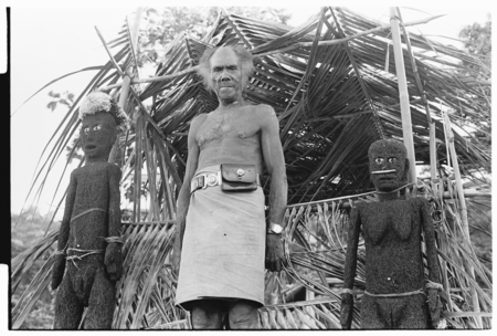 Folofo&#39;u, wearing old police belt, on speaking platform with fernwood &#39;ea figures made by Arimae of Furi&#39;ilae for the open...