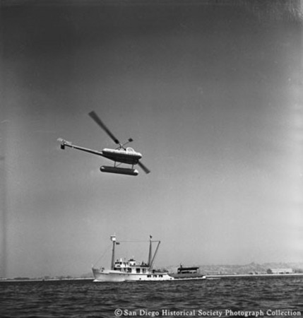 Tuna scout helicopter Chicken of the Sea flying above tuna boat in San Diego Bay