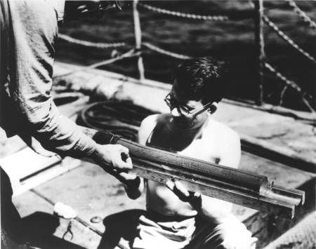 Arthur Raff and Ronald G. Mason (with sample tray) examining bottom sediment core, about 150 miles southwest off San Diego