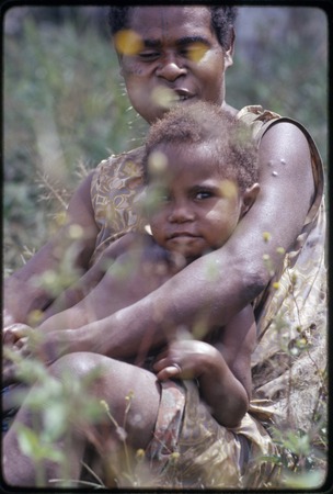 Western Highlands: woman with face tattoo holding a young child