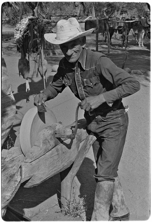 Rancher sharpening machete in Misión Guadalupe area