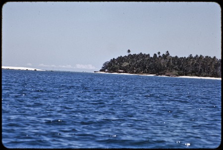 Kaileuna Island: distant view of beach, village and palm trees