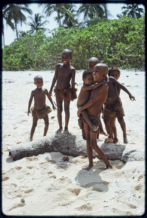 Children on the beach at Kaibola, several with shaved heads as a sign of mourning, girl in center wears turtle shell earrings