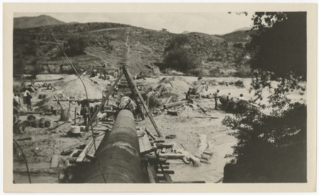 Laying steel pipeline for repairs to the San Diego flume following the flood of 1916