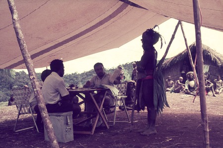 Government officials from Mendi (the district capital) collect an oral election ballot from man at right