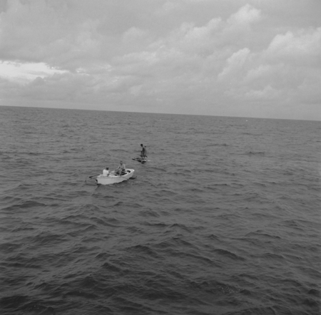 John D. Isaacs and unidentified man in skiff, with Willard Bascom on raft