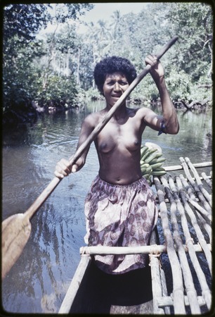 Kaiyabai&#39;i paddles small canoe on a river, with cargo of bananas