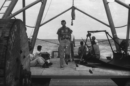 John MacFall, official Capricorn Expedition (1952-1953) photographer (man in center) shown here taken a walk on the deck o...