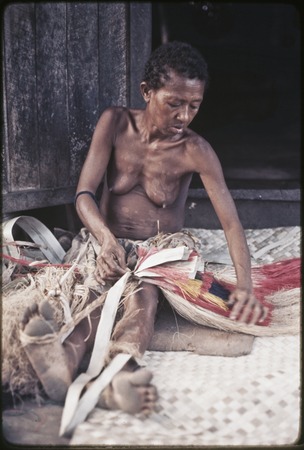 Weaving: woman makes multi-layer, dyed skirt from banana and pandanus-leaf fibers, she sits on mat of woven pandanus leaves