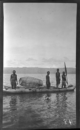 Men in canoe with a woven fish trap, New Britain; man on left holding paddle