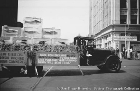 Truck in parade on Broadway displaying fish that &quot;brought 80,000 sportfishermen to San Diego&quot; and that &quot;were packed by har...