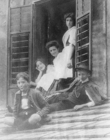 Walter Munk as a child (in hat), his sister Gertrude (head on hand), and their cousins on a window sill and rooftop in Aus...