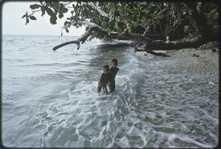 Children play in surf, on the east coast of Kiriwina,