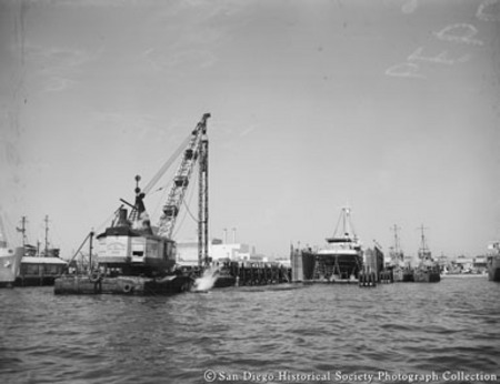 View of San Diego waterfront near Sun Harbor Packing Corporation showing pile driver and boatyard