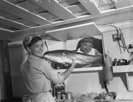 Mrs. V. Ellen Chamberlin and C.R. Bahruth in galley aboard El Monte showing off part of day&#39;s catch