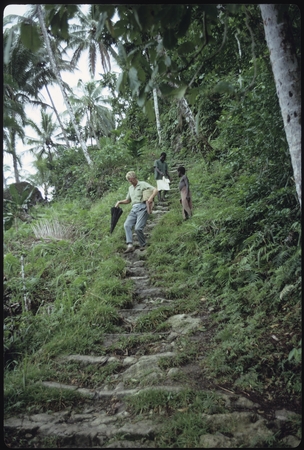Father Laughman, man, and boy coming down hillside steps