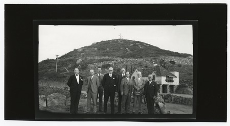Group portrait outside of home on Mount Helix, with cross in background