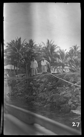 Two Europeans on rock wharf, possibly at Vella Lavella