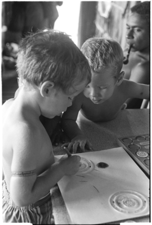 Felicia Keesing draws with a Spirograph, watched by brother, Ronald.