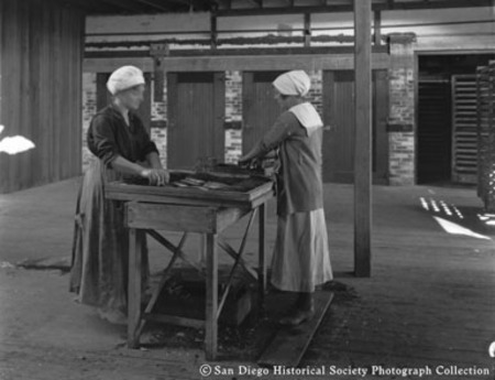 Two women canning fish at Neptune Sea Food Company cannery
