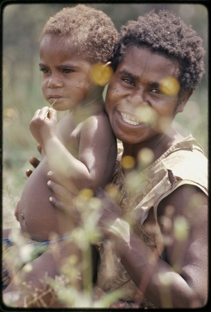 Western Highlands: smiling woman with face tattoo, holding young child