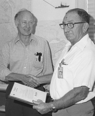 Earl D. Bronson receiving service citation from the U.S. Navy, shaking hands with Fred N. Spiess (left)