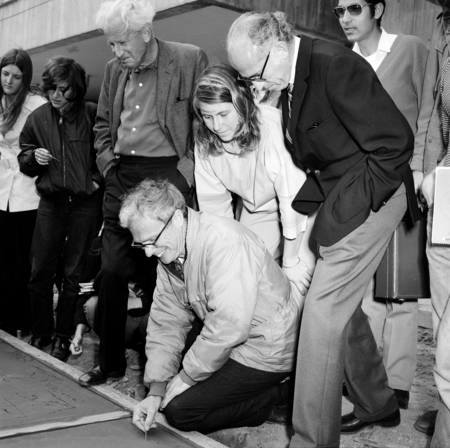 John Stewart writing name in cement with Jonas Salk and others watching, Muir College, UC San Diego