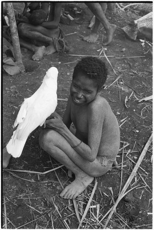 Fainjur: child with fungal skin infection holds white cockatoo