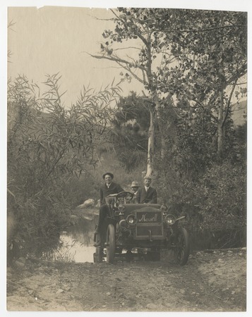 Ed Fletcher, John Nolan and George Marston in Maxwell car fording Cedar Creek, Julian, California