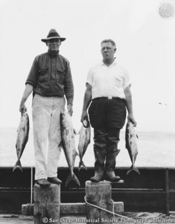 Two men posing with catch of fish