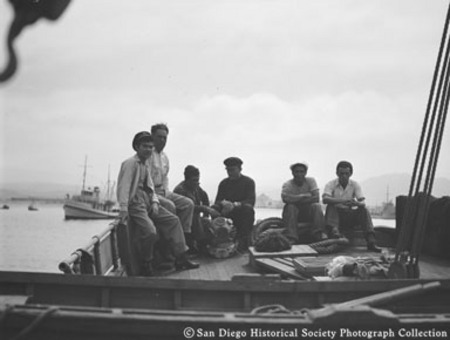 Men sitting on [American Agar Company?] boat