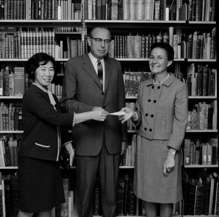 Beatrice Hom and Ms. Drew present check for $100 to Library Director Melvin Voigt, UC San Diego