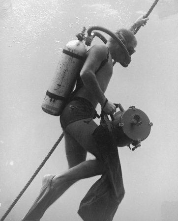 Diver Philip E. Jackson carries an underwater camera and grips line leading to research ship