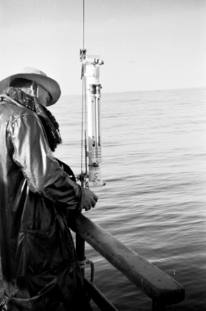 Crewmember using a Nansen bottle, which obtains seawater samples at a specific depth, aboard R/V E.W. Scripps