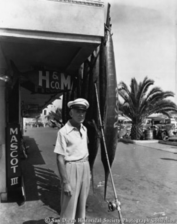Man posing with catch of swordfish at H &amp; M Sport Fishing Company