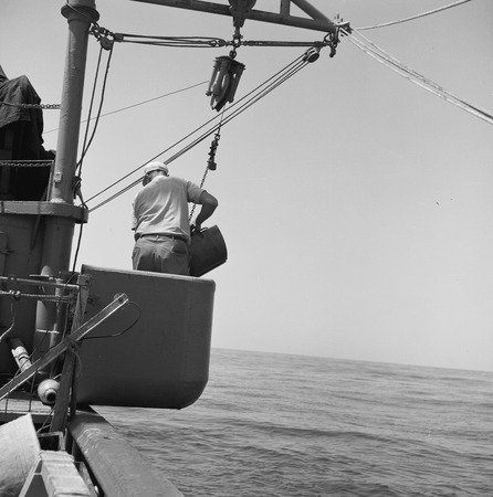 [Deploying the Peterson grab sampler from bucket on deck of R/V Spencer F. Baird]