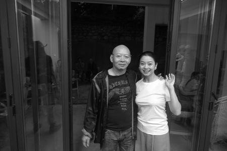 Yue Minjun and wife Yue Er in front of their family house in Dali 3 of 3