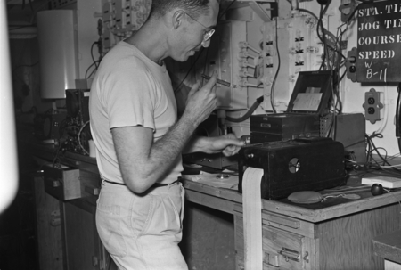 [Man smoking at instrument station in lab on R/V Spencer F. Baird]