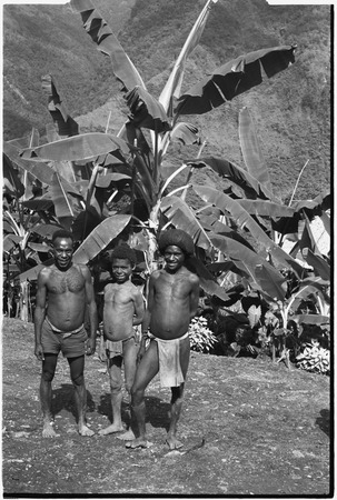 Fainjur: men, one wearing barkcloth cap, and boy in garden, banana trees
