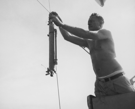 Roger Revelle attaches Nansen bottle to lowering cable from starboard bucket