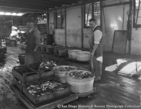 Two men [washing fish?] at Neptune Sea Food Company cannery