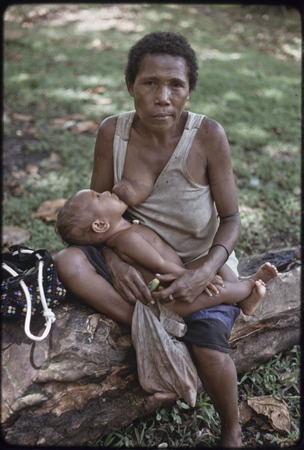 Mother, chewing betel nut, breastfeeds infant